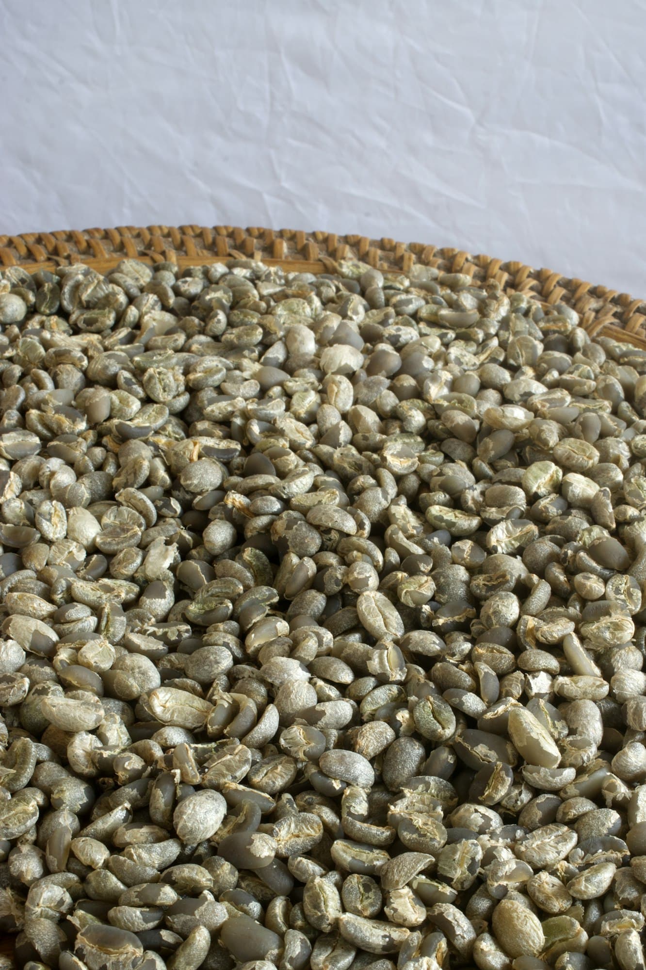 Grano verde de café en un canasto de mimbre